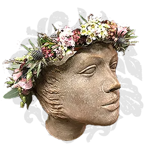 Bild - Steinkopf mit Blumenkranz